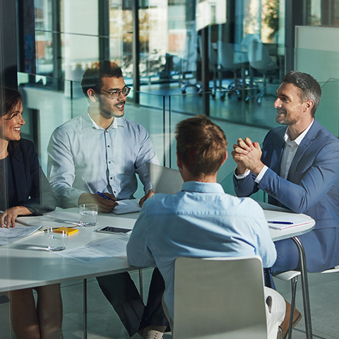 business meeting collaboration teamwork three professionals sitting at a table